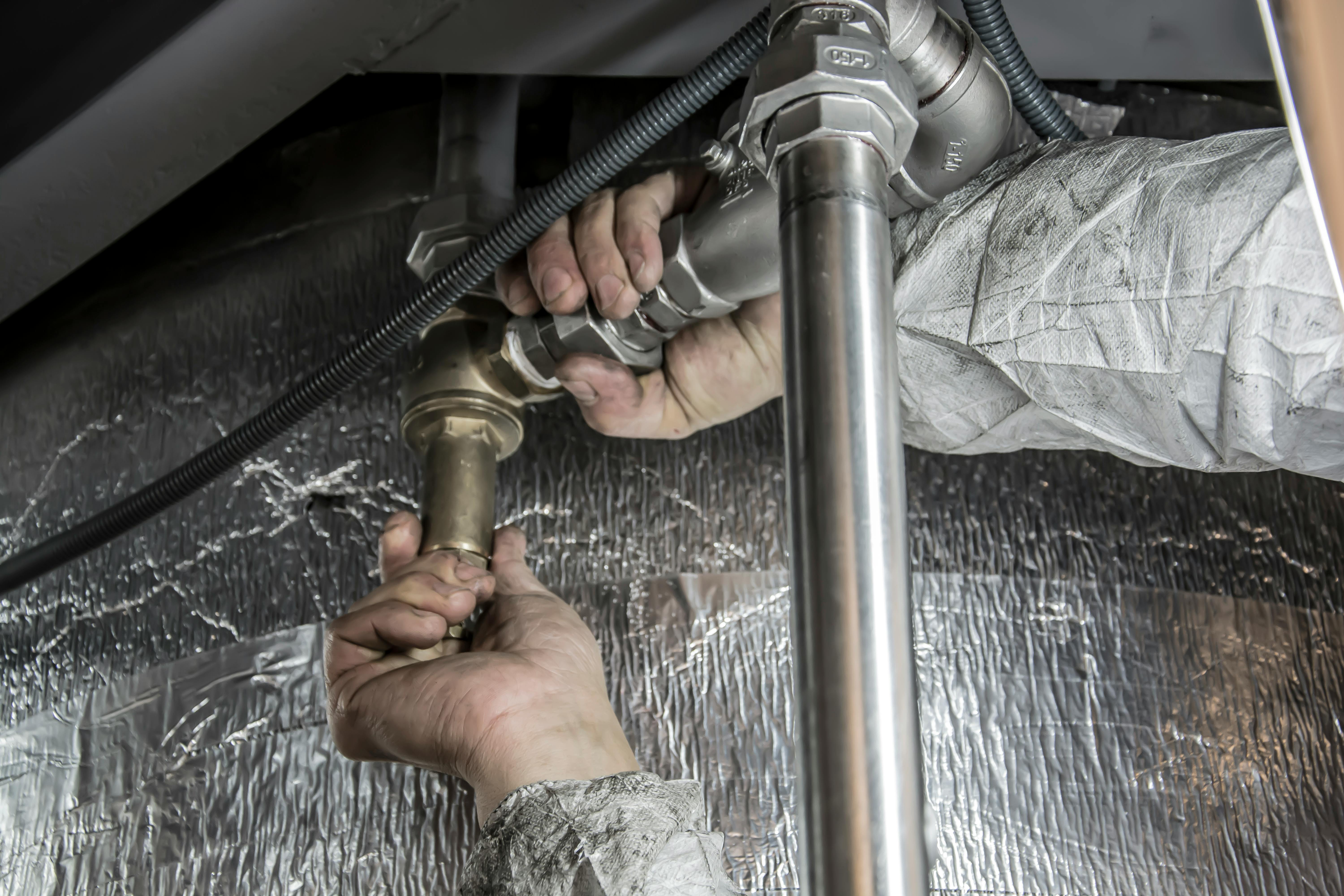 man fixing pipe - flooded basement solutions for immediate action