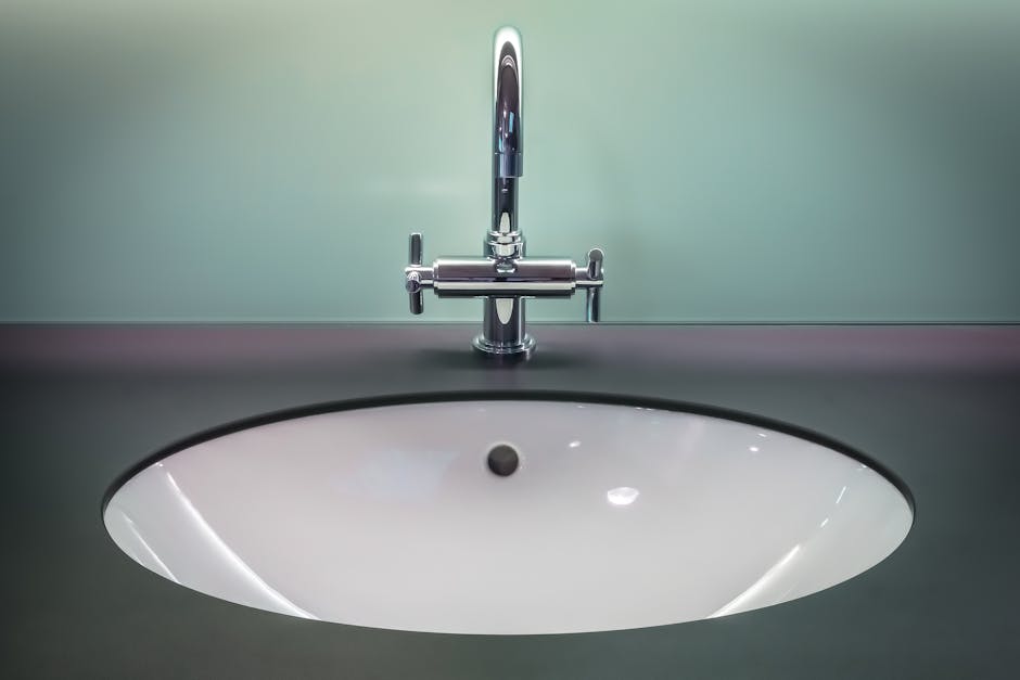 A sleek modern bathroom sink with a shiny stainless steel faucet on a dark vanity - Guide to Choosing the Perfect Water Heater