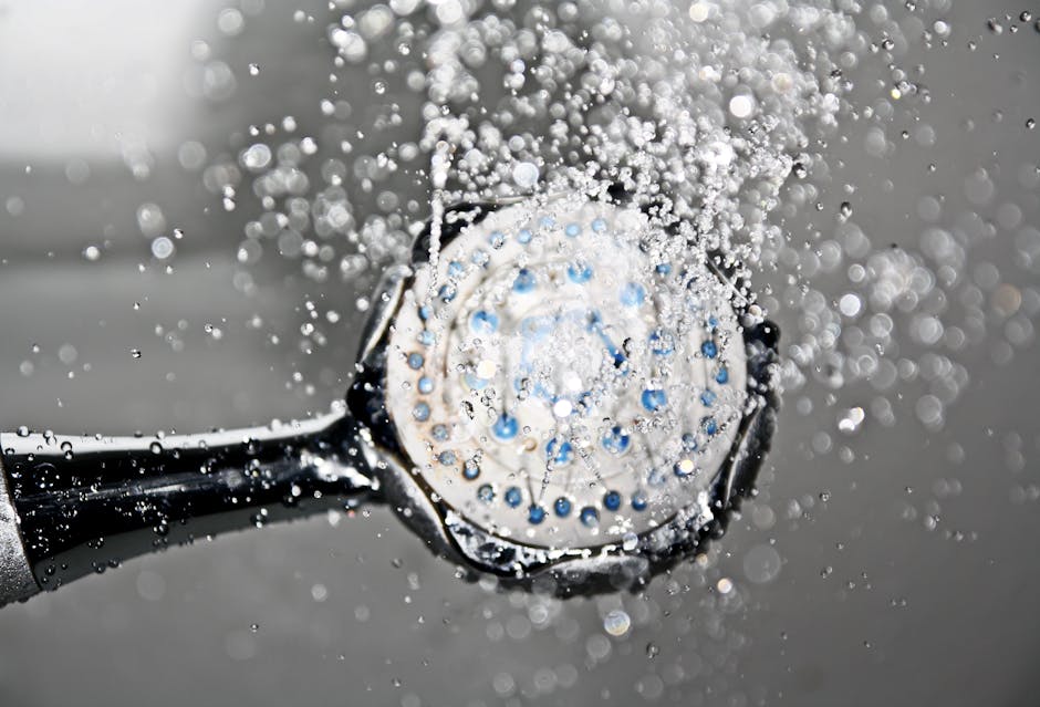 Close-up of a shower head releasing water droplets, creating a crisp and refreshing bathroom scene. - Guide to Choosing the Perfect Water Heater